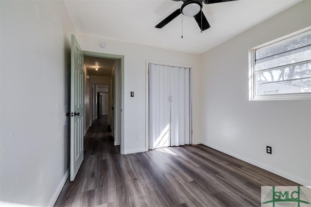 unfurnished bedroom with ceiling fan, dark wood-type flooring, and a closet