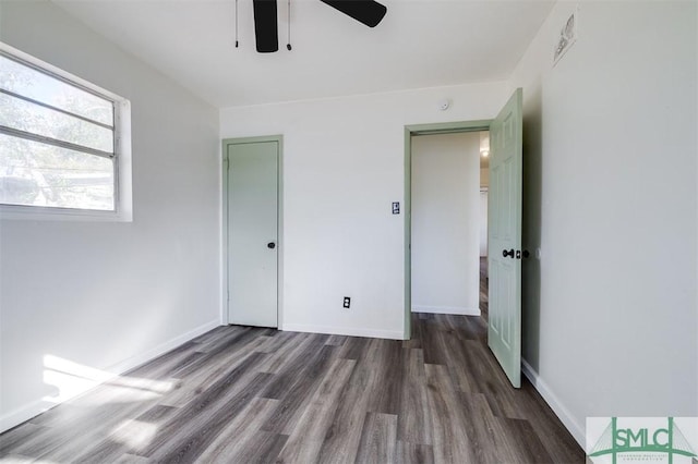 unfurnished bedroom with ceiling fan and dark hardwood / wood-style flooring