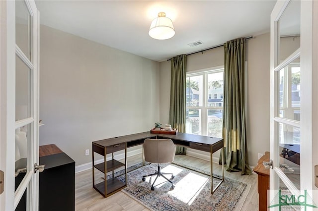 office area with french doors and light hardwood / wood-style flooring