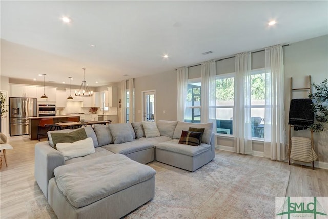 living room featuring light hardwood / wood-style floors and a notable chandelier