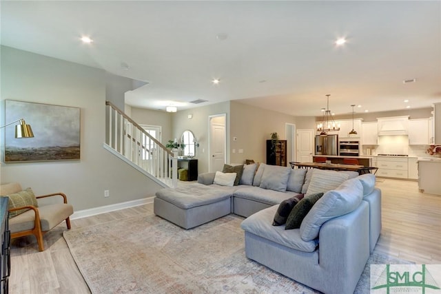 living room featuring a notable chandelier and light hardwood / wood-style flooring