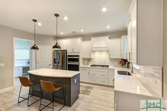 kitchen with white cabinets, a kitchen island, sink, and stainless steel appliances