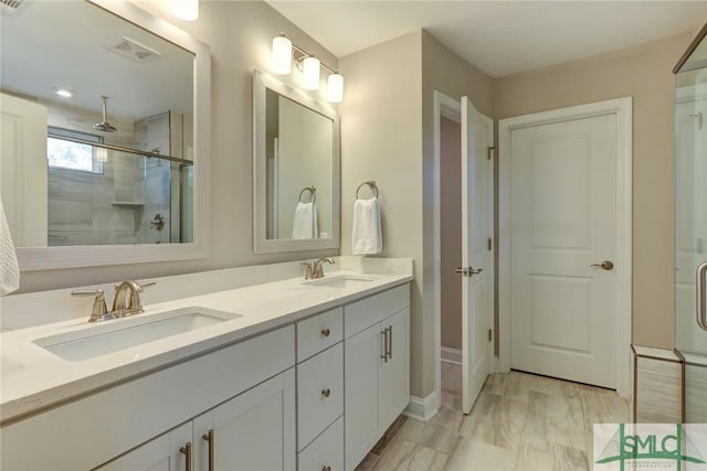 bathroom featuring vanity and a shower with shower door