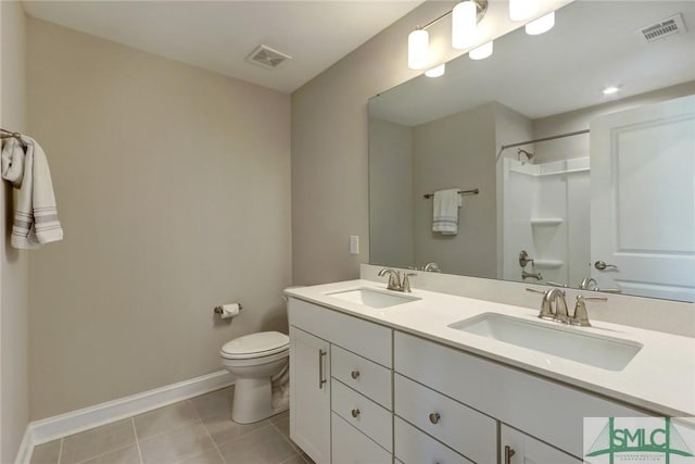 bathroom featuring tile patterned flooring, vanity, toilet, and walk in shower