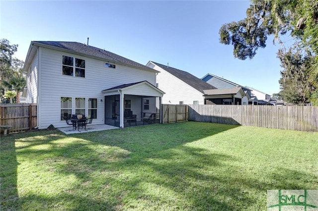 rear view of property featuring a yard, a patio area, and a sunroom