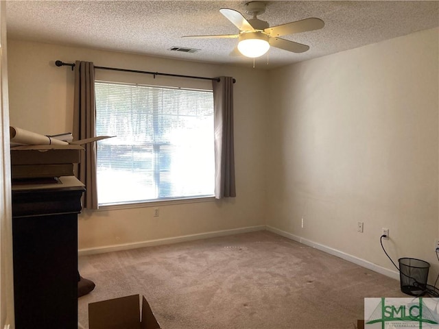 interior space featuring a textured ceiling, carpet floors, and ceiling fan