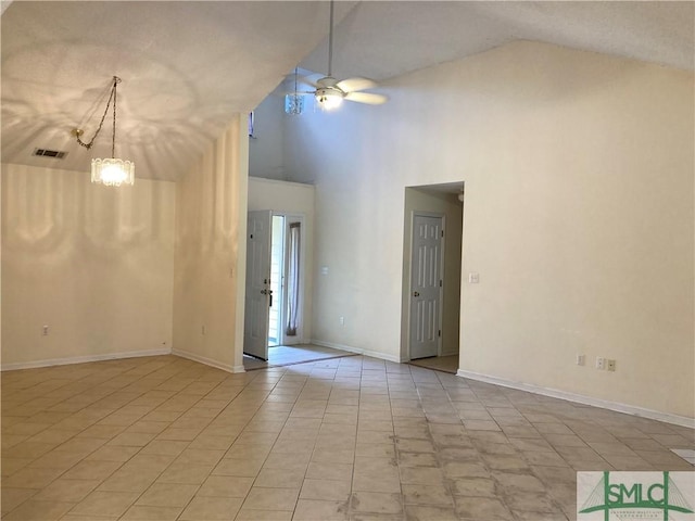 empty room with high vaulted ceiling, a ceiling fan, visible vents, and baseboards