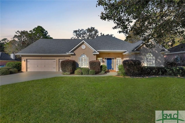 view of front of home with a lawn and a garage