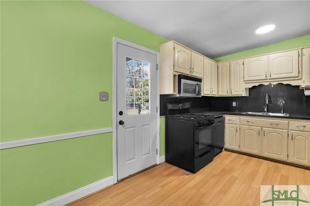 kitchen featuring decorative backsplash, black gas range, light hardwood / wood-style flooring, and sink