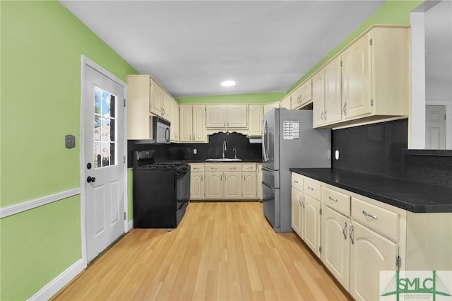 kitchen with decorative backsplash, appliances with stainless steel finishes, light hardwood / wood-style flooring, and sink