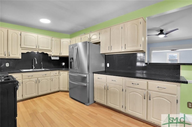 kitchen featuring ceiling fan, sink, stainless steel refrigerator with ice dispenser, black / electric stove, and light hardwood / wood-style floors