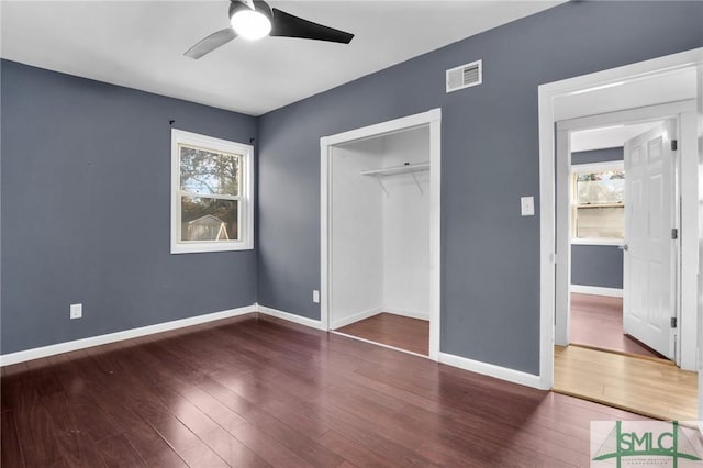 unfurnished bedroom featuring dark hardwood / wood-style floors, a closet, and ceiling fan