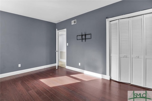 unfurnished bedroom featuring hardwood / wood-style flooring and a closet