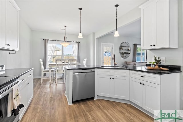 kitchen with appliances with stainless steel finishes, decorative light fixtures, white cabinetry, and sink