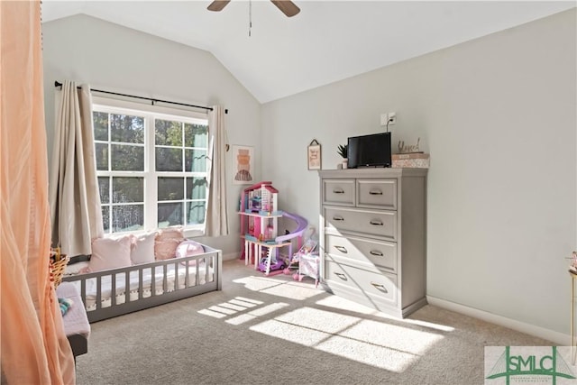 carpeted bedroom with ceiling fan, a nursery area, and vaulted ceiling