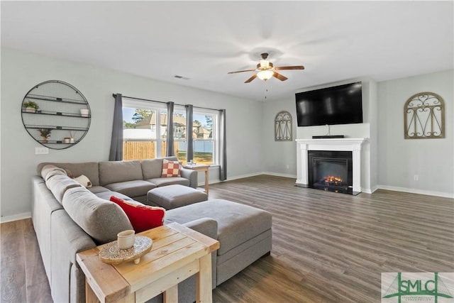 living room featuring ceiling fan and dark hardwood / wood-style flooring