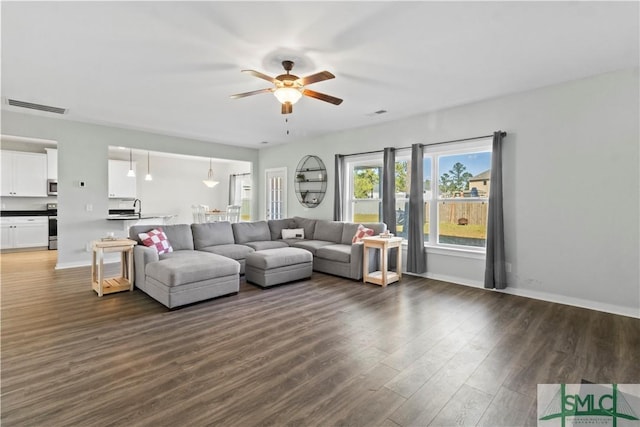 living room with ceiling fan and dark hardwood / wood-style floors