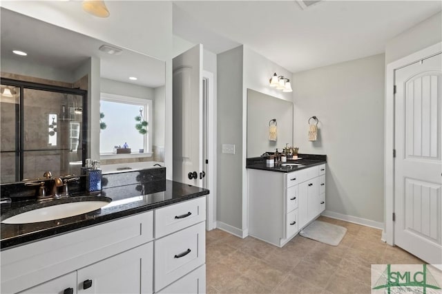 bathroom with tile patterned flooring, vanity, and walk in shower