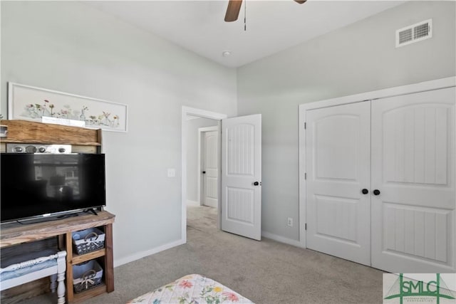 bedroom featuring light carpet, a closet, and ceiling fan