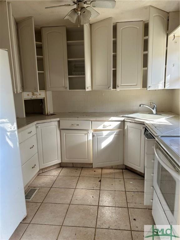 kitchen featuring backsplash, sink, white cabinets, and white appliances