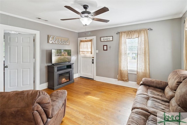 living room featuring light wood-type flooring, ceiling fan, and crown molding