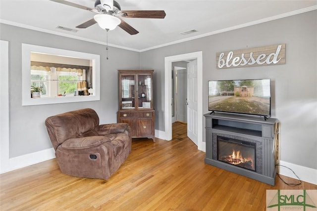 living room with ceiling fan, hardwood / wood-style floors, and ornamental molding