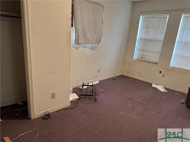 unfurnished bedroom with multiple windows, baseboards, and carpet flooring