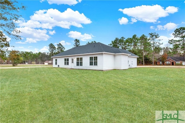 rear view of house featuring a yard