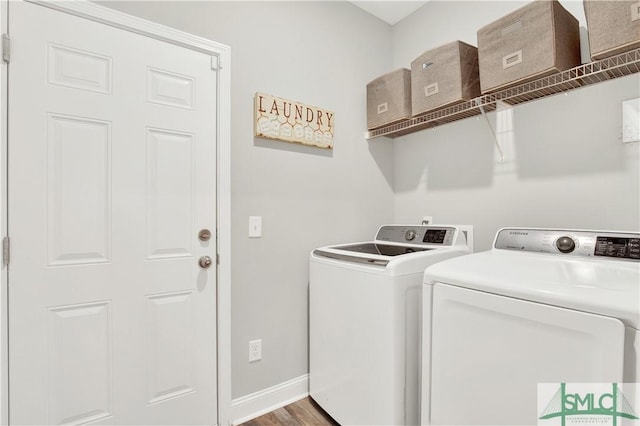 clothes washing area featuring washing machine and clothes dryer and hardwood / wood-style flooring