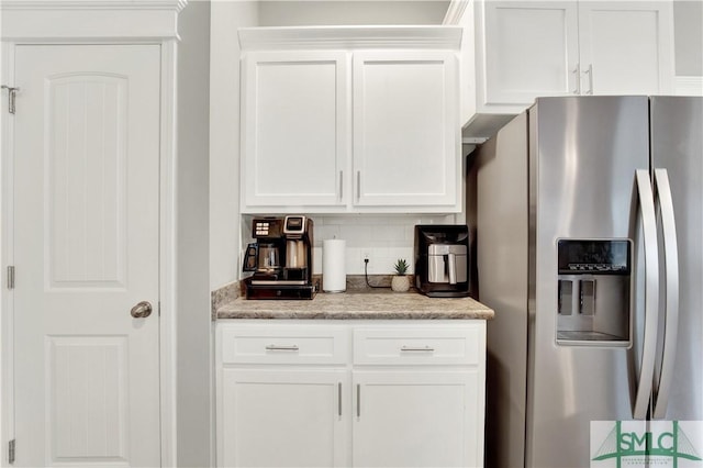 kitchen featuring light stone countertops, stainless steel fridge with ice dispenser, backsplash, and white cabinetry