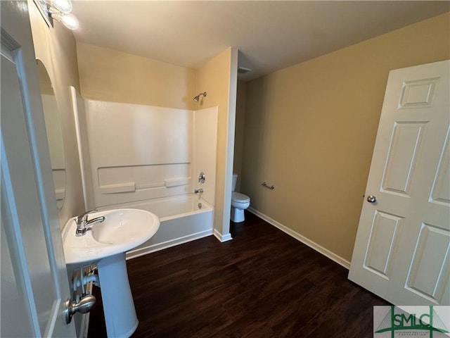 bathroom featuring hardwood / wood-style flooring, toilet, and shower / bathing tub combination