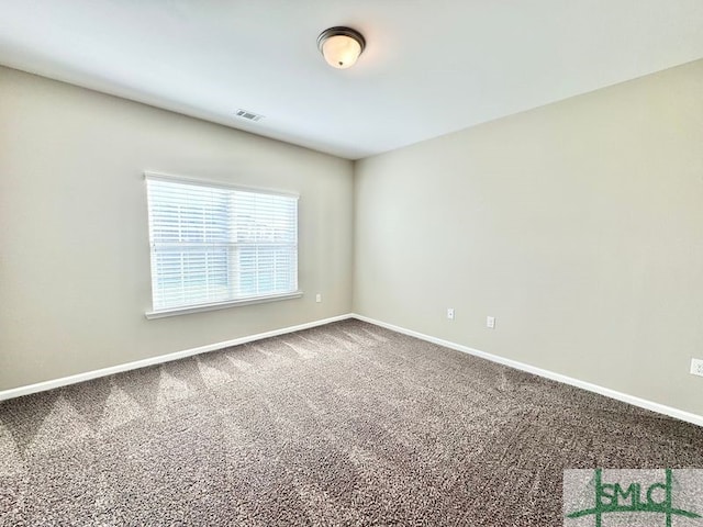 carpeted spare room featuring visible vents and baseboards