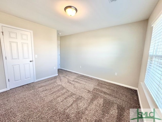 unfurnished room with visible vents, baseboards, and carpet flooring