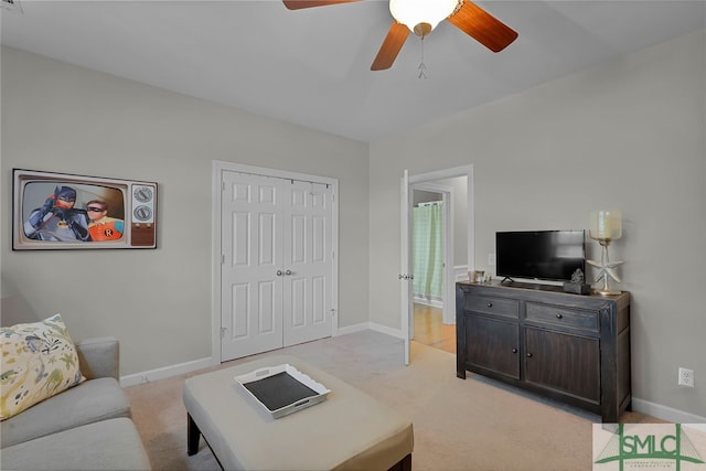 carpeted living room with ceiling fan