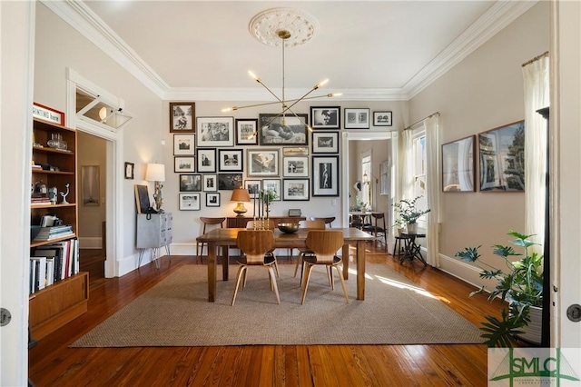 dining room featuring crown molding, an inviting chandelier, and hardwood / wood-style flooring