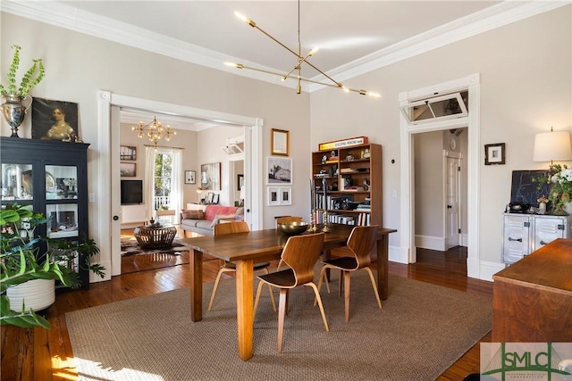 dining area with dark hardwood / wood-style flooring, ornamental molding, and a notable chandelier