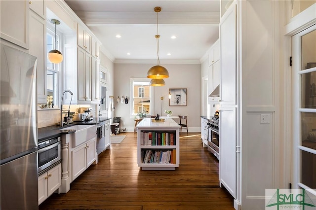 kitchen with decorative light fixtures, white cabinetry, stainless steel appliances, sink, and ventilation hood