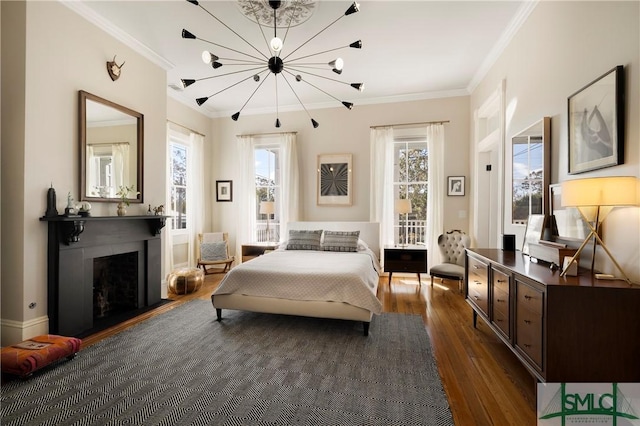 bedroom with access to outside, dark hardwood / wood-style floors, an inviting chandelier, and crown molding