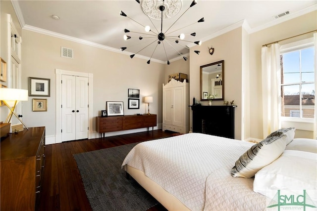 bedroom featuring crown molding, dark hardwood / wood-style floors, and a notable chandelier