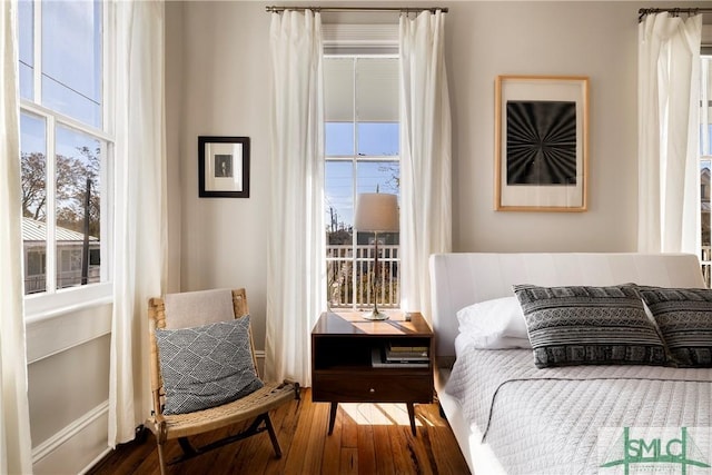 bedroom with dark wood-type flooring and multiple windows