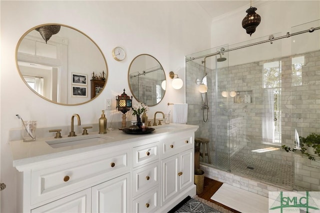 bathroom with a shower with shower door, vanity, and crown molding