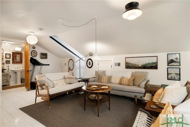 living room with light wood-type flooring, lofted ceiling, and sink