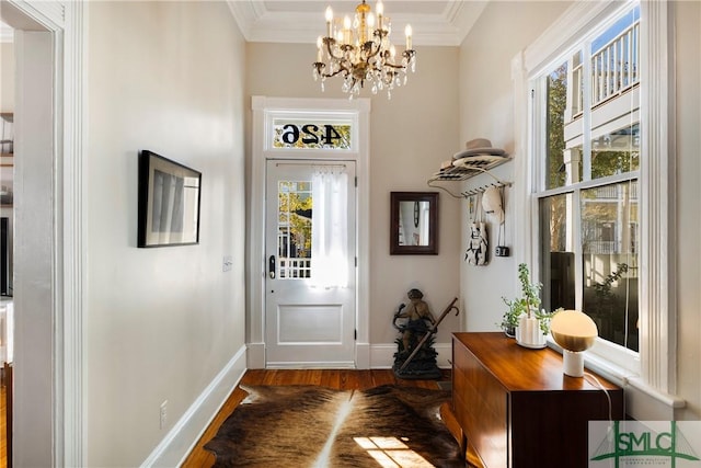 doorway with dark hardwood / wood-style floors, crown molding, and a chandelier