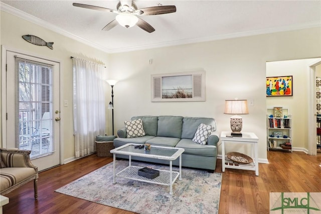 living room featuring hardwood / wood-style floors, ceiling fan, and crown molding