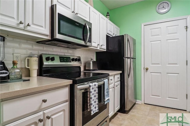 kitchen featuring white cabinets, light tile patterned floors, appliances with stainless steel finishes, and tasteful backsplash