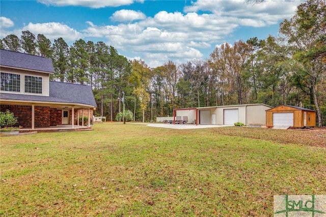 view of yard featuring covered porch, a garage, and an outbuilding