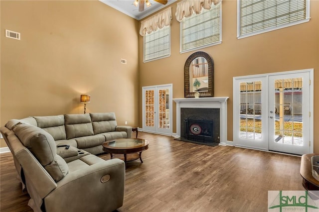 living room featuring french doors, ceiling fan, a high ceiling, and wood-type flooring