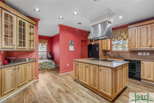 kitchen with black appliances, a kitchen island, a healthy amount of sunlight, and island exhaust hood