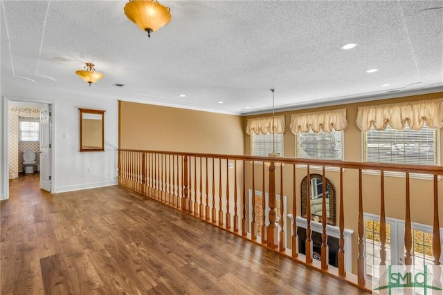 hallway featuring a textured ceiling and hardwood / wood-style flooring