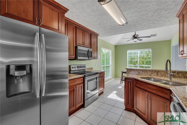 kitchen with a textured ceiling, ceiling fan, sink, and appliances with stainless steel finishes